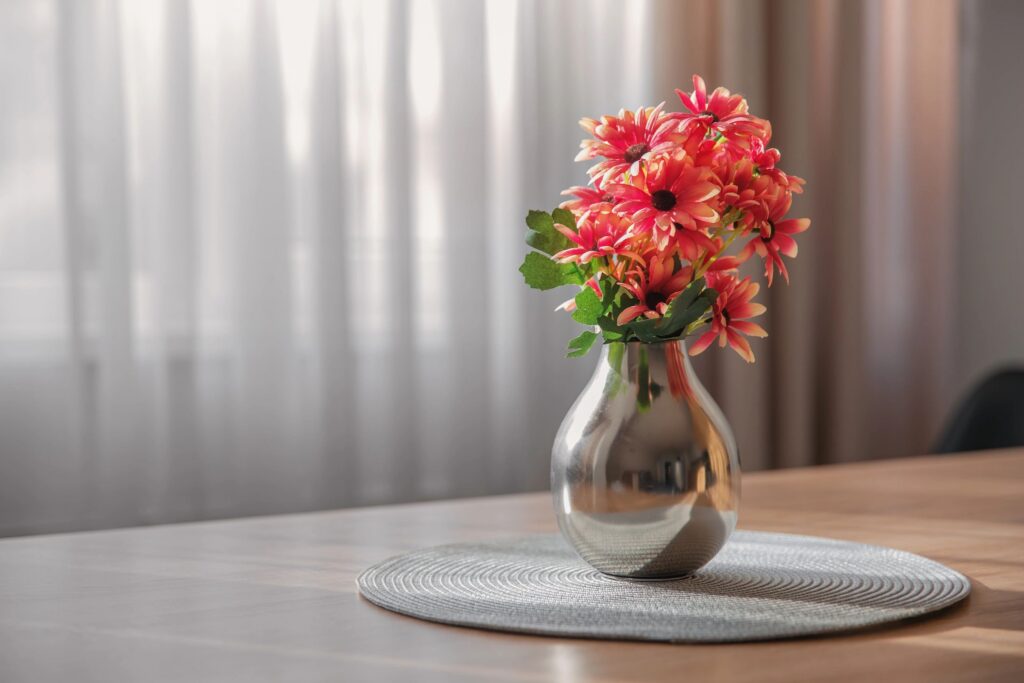 Silver vase with a bouquet of flowers on the table